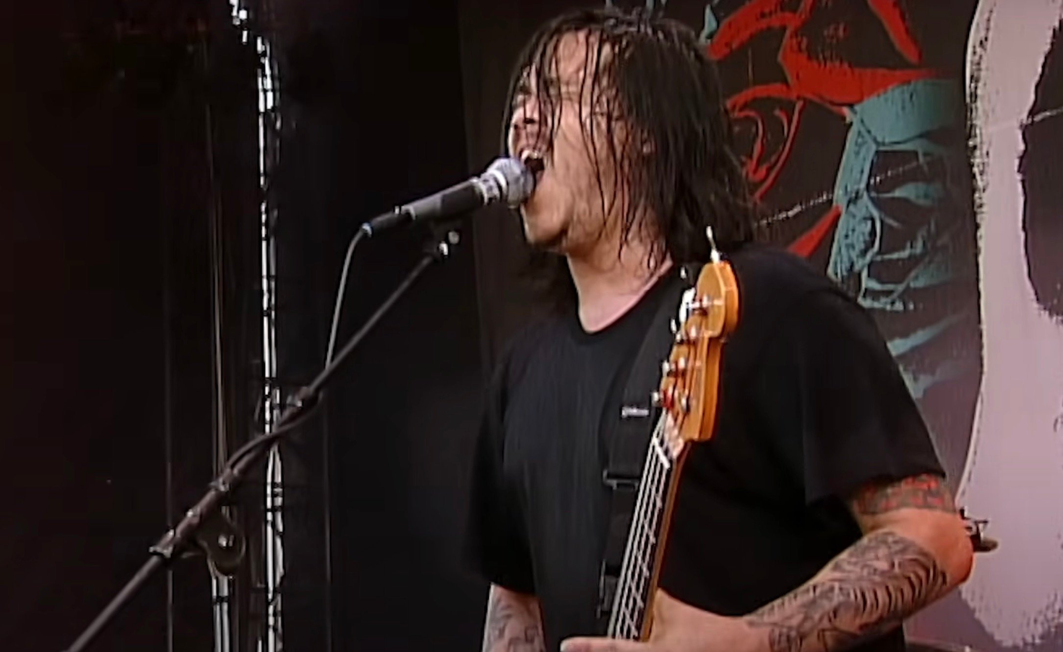 A photo of Chi Cheng playing live with Deftones at Pinkpop 2003.
