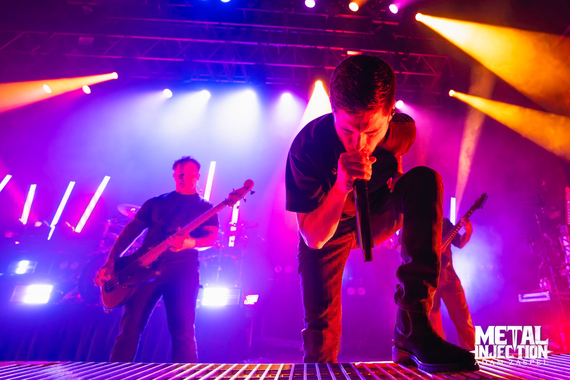 Whitechapel performing live on stage with vocalist Phil Bozeman at the front, delivering an intense deathcore performance under concert lighting.